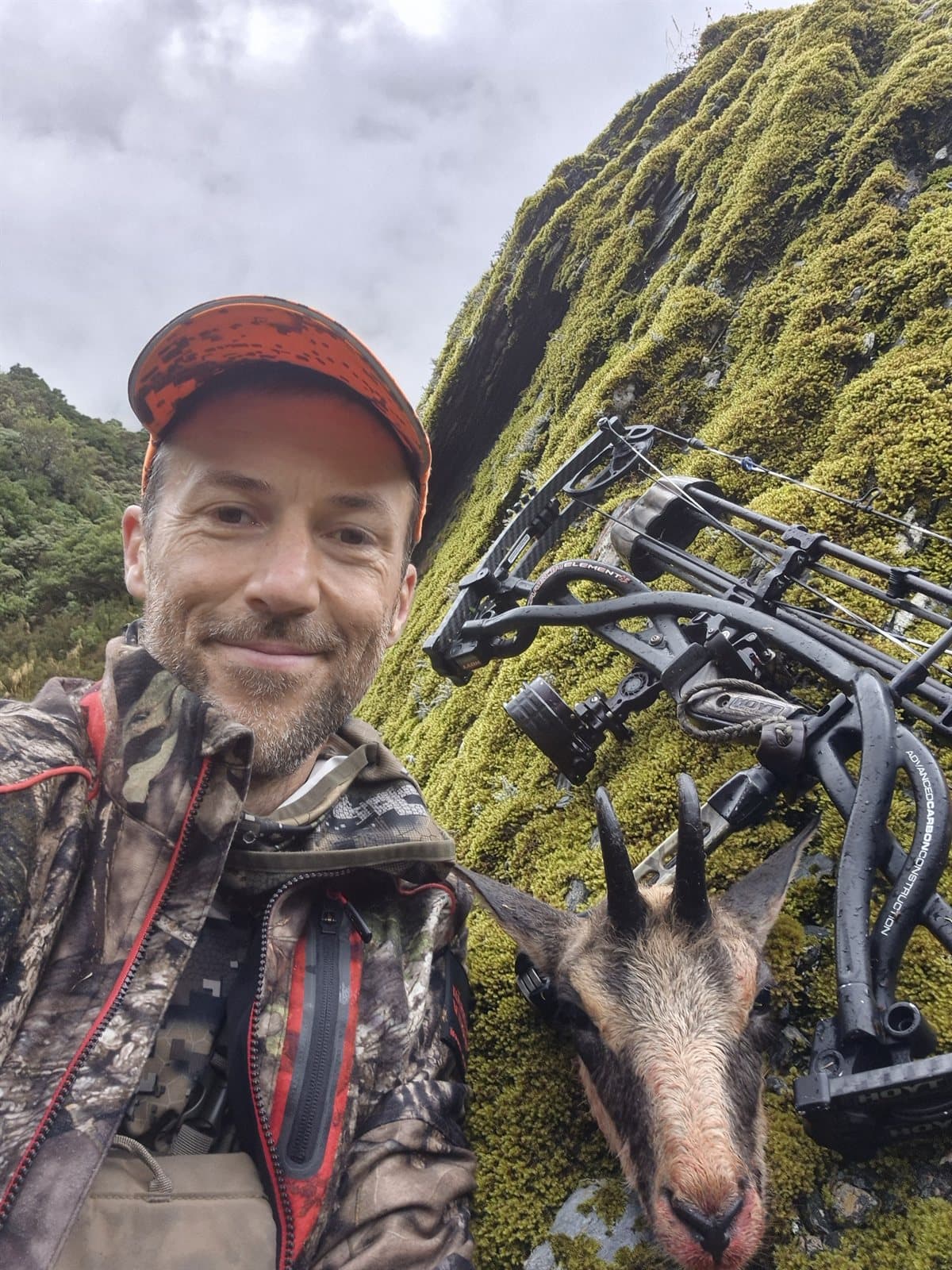 Daniel with bow and chamois in the New Zealand backcountry